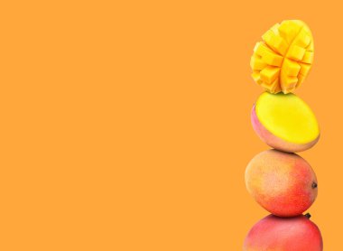 Turuncu arka planda birikmiş taze mango meyveleri, metin için boşluk