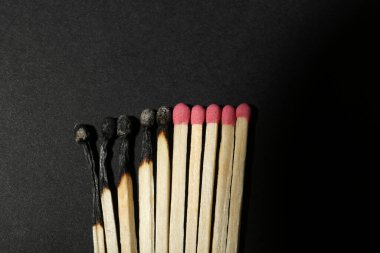 Yanmış ve tüm kibritler siyah arka planda, düz yerde. Yok etme kavramını durdur