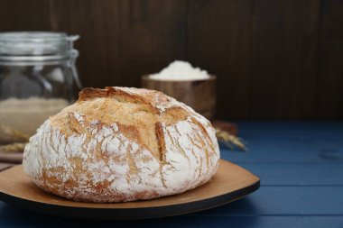 Mavi ahşap masada taze pişmiş ekmek. Metin için boşluk