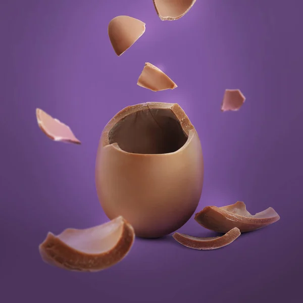 Εκρηκτικό Αυγό Σοκολάτας Γάλακτος Μωβ Φόντο — Φωτογραφία Αρχείου