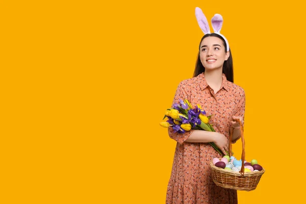 Glückliche Frau Mit Hasenohren Stirnband Hält Weidenkorb Mit Bemalten Ostereiern — Stockfoto