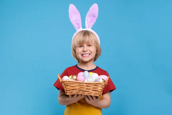 Glücklicher Junge Mit Hasenohren Stirnband Hält Weidenkorb Mit Bemalten Ostereiern — Stockfoto