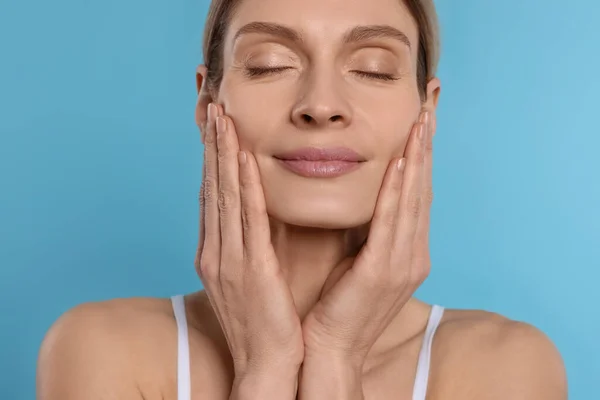 Woman Massaging Her Face Turquoise Background — 스톡 사진