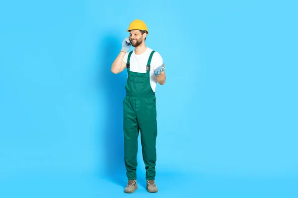 Professionele Reparateur Uniform Praten Smartphone Tegen Lichtblauwe Achtergrond — Stockfoto