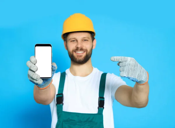 Professional Repairman Uniform Showing Smartphone Light Blue Background Focus Screen — Stock Photo, Image