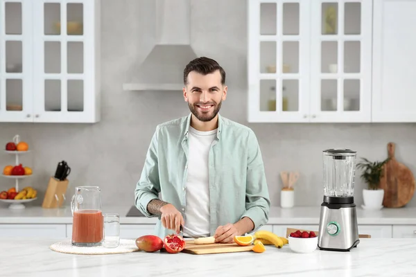 stock image Handsome man preparing ingredients for tasty smoothie at white marble table in kitchen