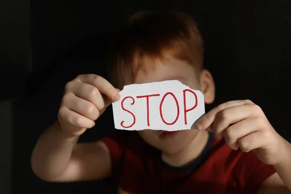 Kleiner Junge Hält Ein Blatt Papier Mit Dem Wort Stop — Stockfoto