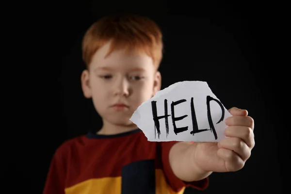 Kleiner Junge Hält Zettel Mit Dem Wort Hilfe Vor Schwarzem — Stockfoto