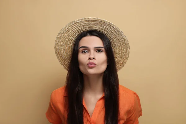 Hermosa Mujer Joven Sombrero Paja Dando Beso Sobre Fondo Beige —  Fotos de Stock