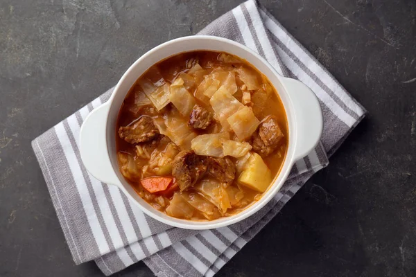 stock image Tasty cabbage soup with meat and carrot on grey table, top view