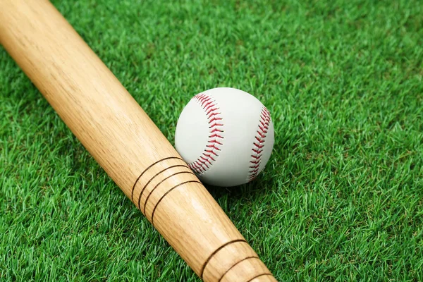 緑の芝生の上で木製の野球バットとボールを閉じます スポーツ用具 — ストック写真