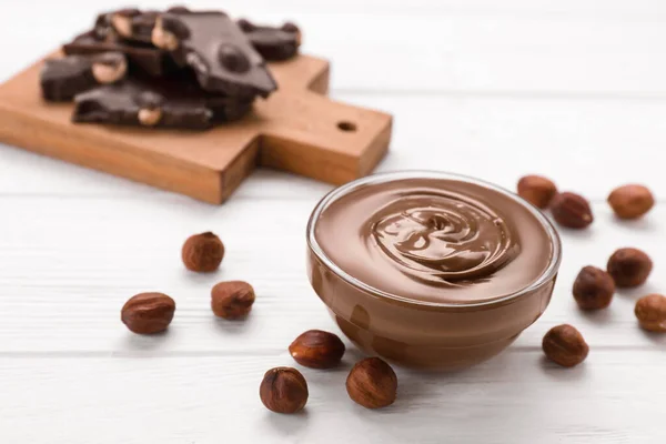 用美味的面糊 巧克力片和坚果装饰在白色木制桌子上的碗 案文的篇幅 — 图库照片