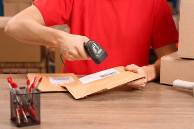 Tarayıcı ile postane çalışanı tezgahta parsel barkodu okuyor, yakın plan