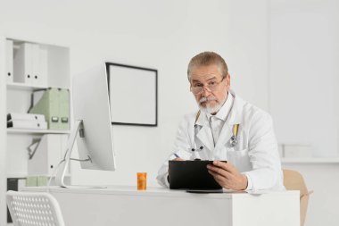 Doctor with patient's medical card at table in clinic