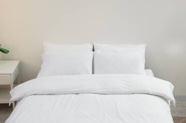 White soft pillows on cozy bed in room