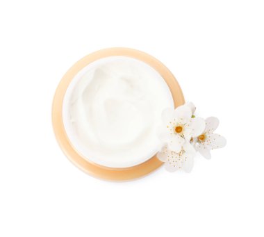 Face cream in jar and flowers on white background, top view