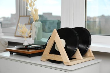 Beyaz ahşap çekmecedeki vinil plaklar ve oyuncu.
