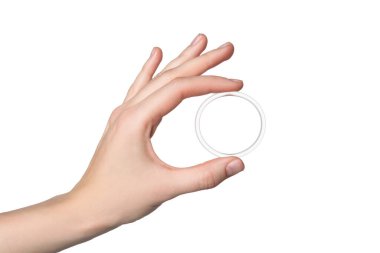 Woman holding diaphragm vaginal contraceptive ring on white background, closeup