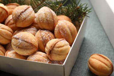 Box with delicious nut shaped cookies on table, closeup