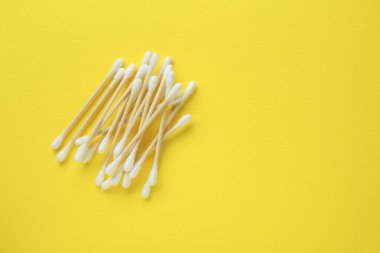 Sarı arka planda bir yığın ahşap pamuk tomurcuğu, düz bir zemin. Metin için boşluk