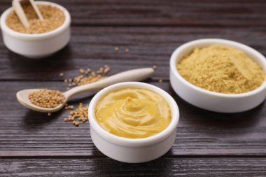 Lezzetli hardal ve tohumlar koyu ahşap masada, yakın plan.