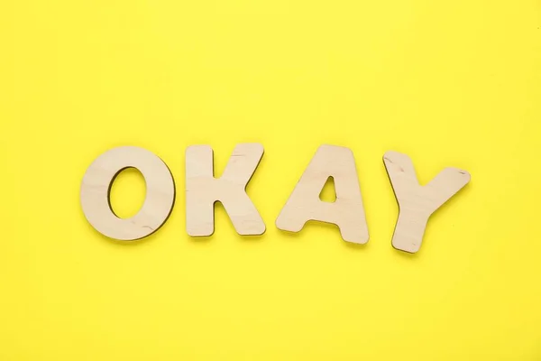 Word Ok黄色の背景に木製の文字で作られた トップビュー — ストック写真