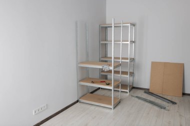 Office room with white walls and metal storage shelves. Space for text