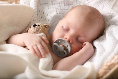 Cute newborn baby sleeping on white blanket, closeup