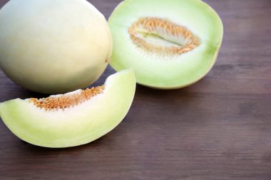 Tasty whole and cut ripe melons on wooden table