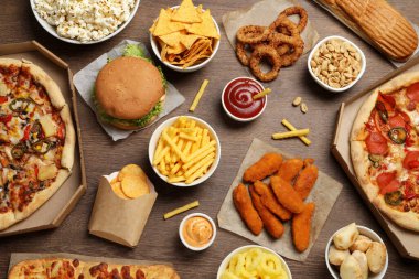 Patates kızartması, cips ve diğer fast food 'lar tahta masada, düz yatıyordu.