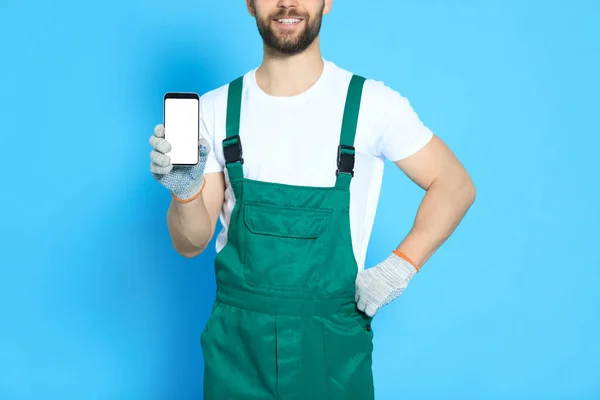 Professionele Reparateur Uniform Met Smartphone Lichtblauwe Achtergrond Close — Stockfoto