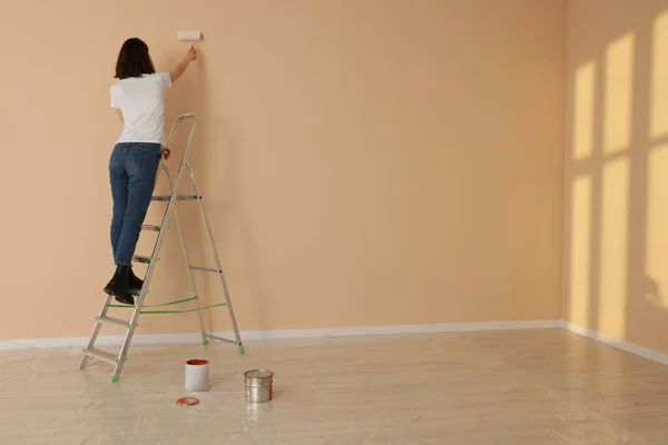 Young Woman Painting Wall Roller Stepladder Indoors Space Text Room — Foto de Stock