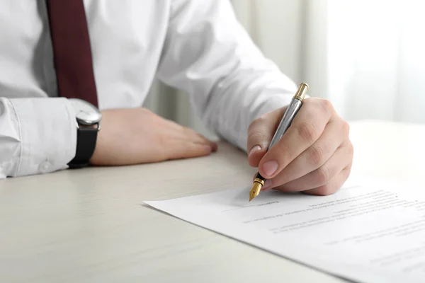 stock image Notary signing document at wooden table indoors, closeup