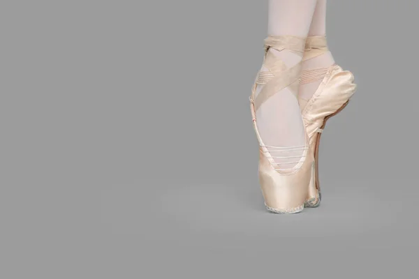 グレーの背景にダンスの動きを練習している点の靴の若いバレリーナ クローズアップ テキストのスペース — ストック写真