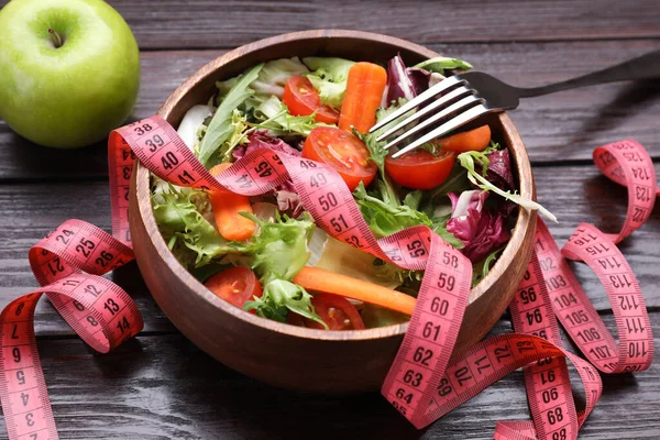 碗与新鲜蔬菜沙拉 苹果和测量带在木制桌子上 健康饮食概念 — 图库照片