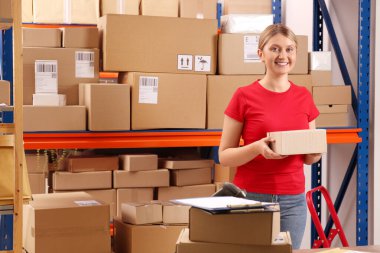Post office worker with parcel near rack indoors