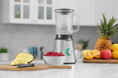 Blender ve smoothie malzemeleri mutfaktaki beyaz mermer masada.
