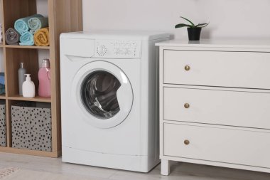 Çamaşır makinesi ve çekmeceli şık bir çamaşır odası. İç tasarım