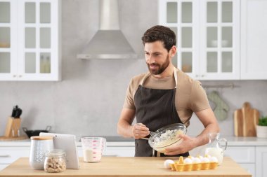 Adam mutfakta tabletle çevrimiçi yemek kursunu izlerken para kazanıyor.