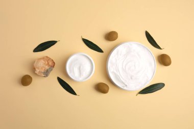 Natural cosmetic. Different olive creams, mineral and ingredient on beige background, flat lay