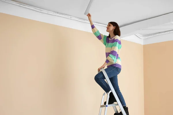 Young Woman Installing Ceiling Lamp Stepladder Indoors Space Text — Stockfoto