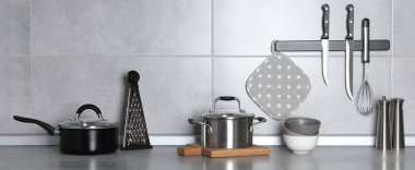 Mutfaktaki gri tezgahta mutfak gereçleri ve yemek takımları, pankart tasarımı