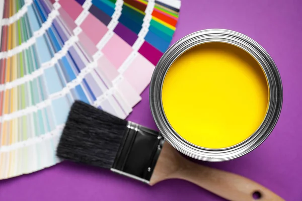 노란색 페인트 팔레트 사용하여 보라색 배경에 면을칠 수있다 — 스톡 사진