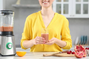 Mutfakta nefis smoothie 'si olan kadın, yakın plan.