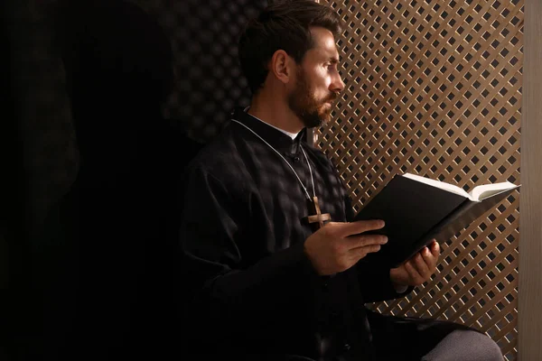 Katolicki Ksiądz Sutannie Czytający Biblię Konfesjonale — Zdjęcie stockowe