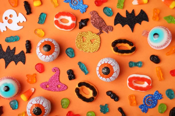 Leckere Bonbons Und Halloween Dekorationen Auf Orangefarbenem Hintergrund Flache Lage — Stockfoto