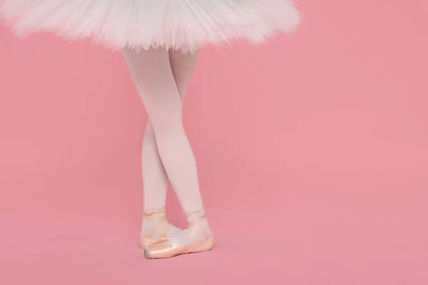 穿着尖皮鞋的年轻芭蕾舞演员在粉色背景下练习跳舞 案文的篇幅 — 图库照片