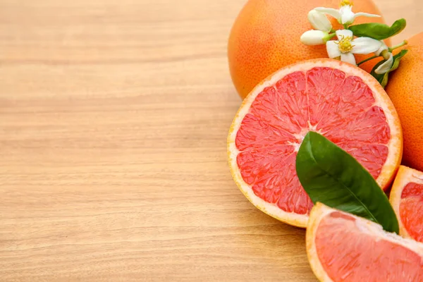 Frische Reife Grapefruits Blüten Und Grüne Blätter Auf Einem Holztisch — Stockfoto