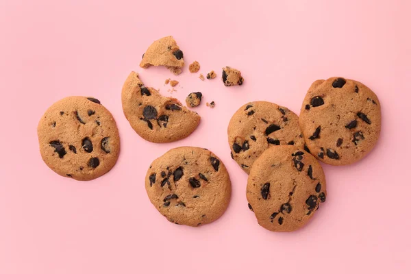 薄いピンクの背景に多くのおいしいチョコレートチップクッキー フラットレイ — ストック写真