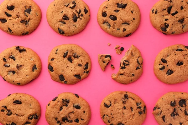 stock image Many delicious chocolate chip cookies on pink background, flat lay